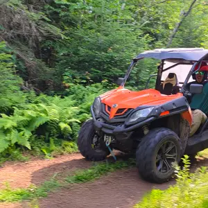 A person driving a UTV at Farmhouse UTVs in Saranac Lake.